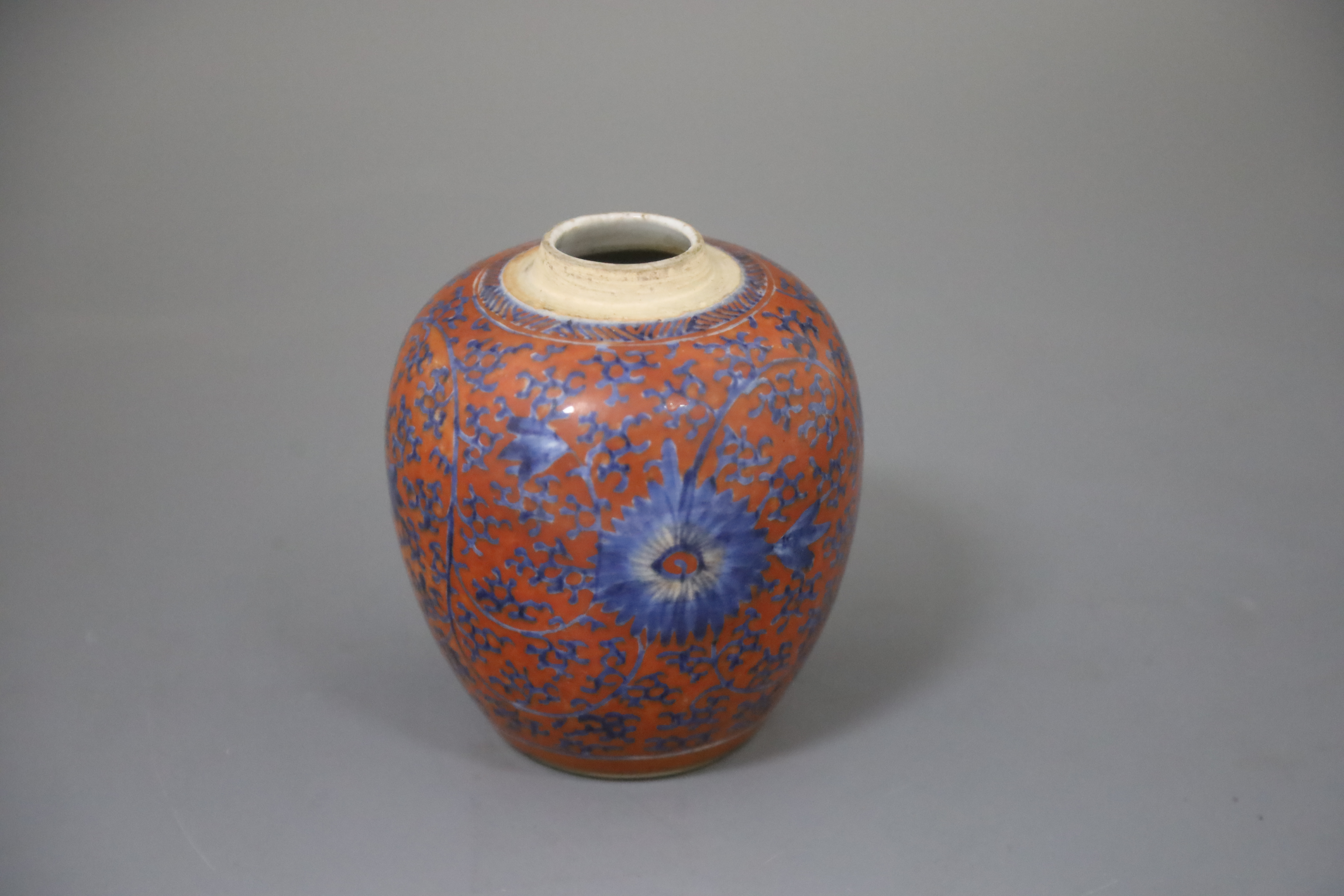 A Chinese coral red ground underglaze blue jar, Kangxi period, H. 12.3cm, excluding wood cover and stand